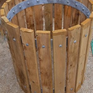 The wood slats of these 55 gallon outdoor waste receptacle provide a warm, natural look that blends beautifully with the landscape.